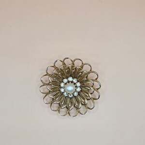 Vintage gold brooch with rhinestone & pearl center swirling open floral design